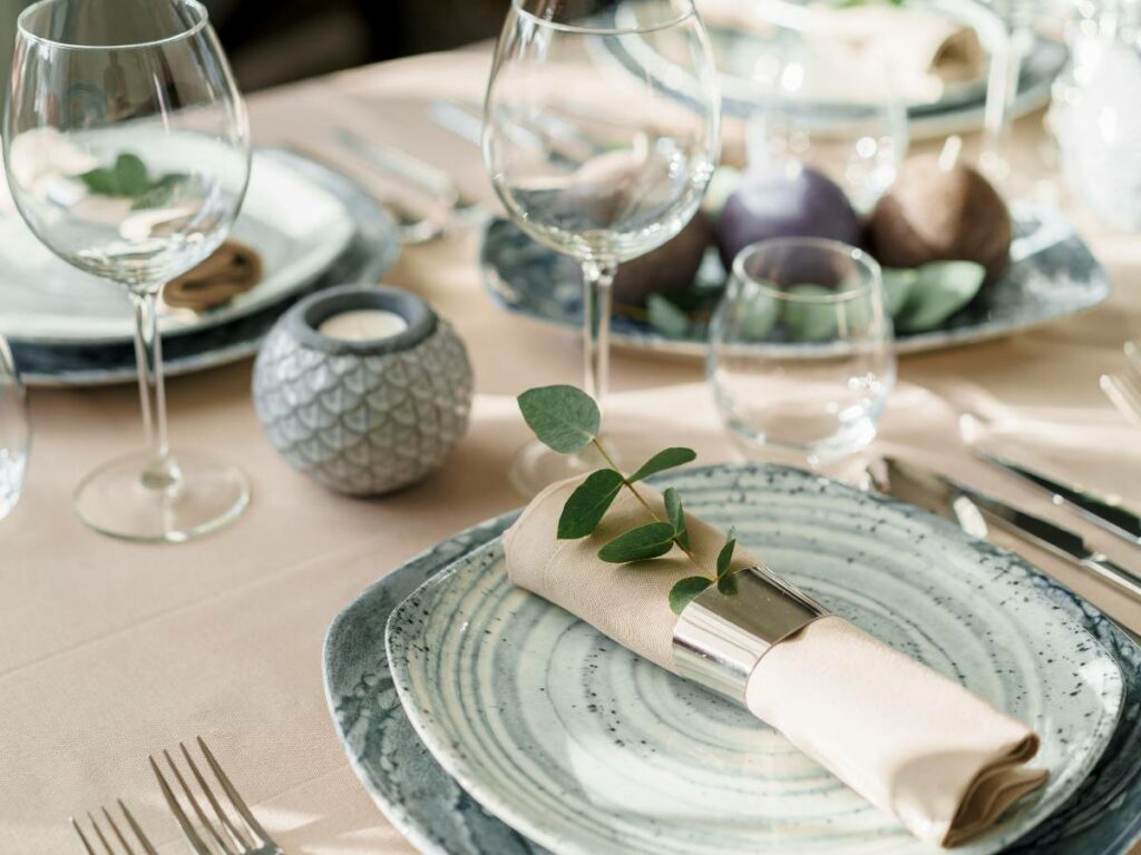 Table setting showing plates, silverware, and glasses.
