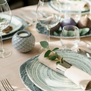 Table setting showing plates, silverware, and glasses.