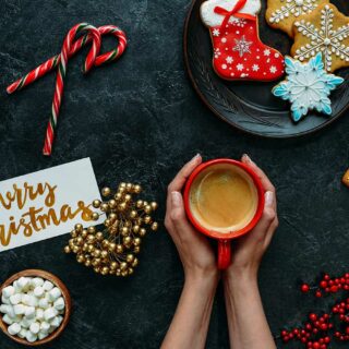 A woman holding a cup of Christmas blend coffee.