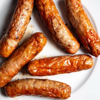 Breakfast sausages on a plate on a wooden table.