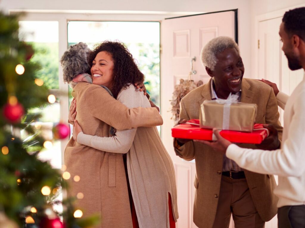 A family hugging and holding a christmas present.