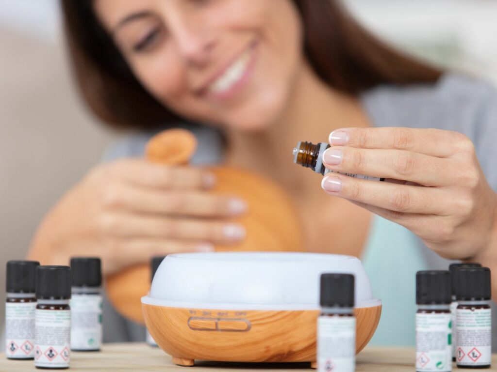 A woman is holding a diffuser with essential oils around it.
