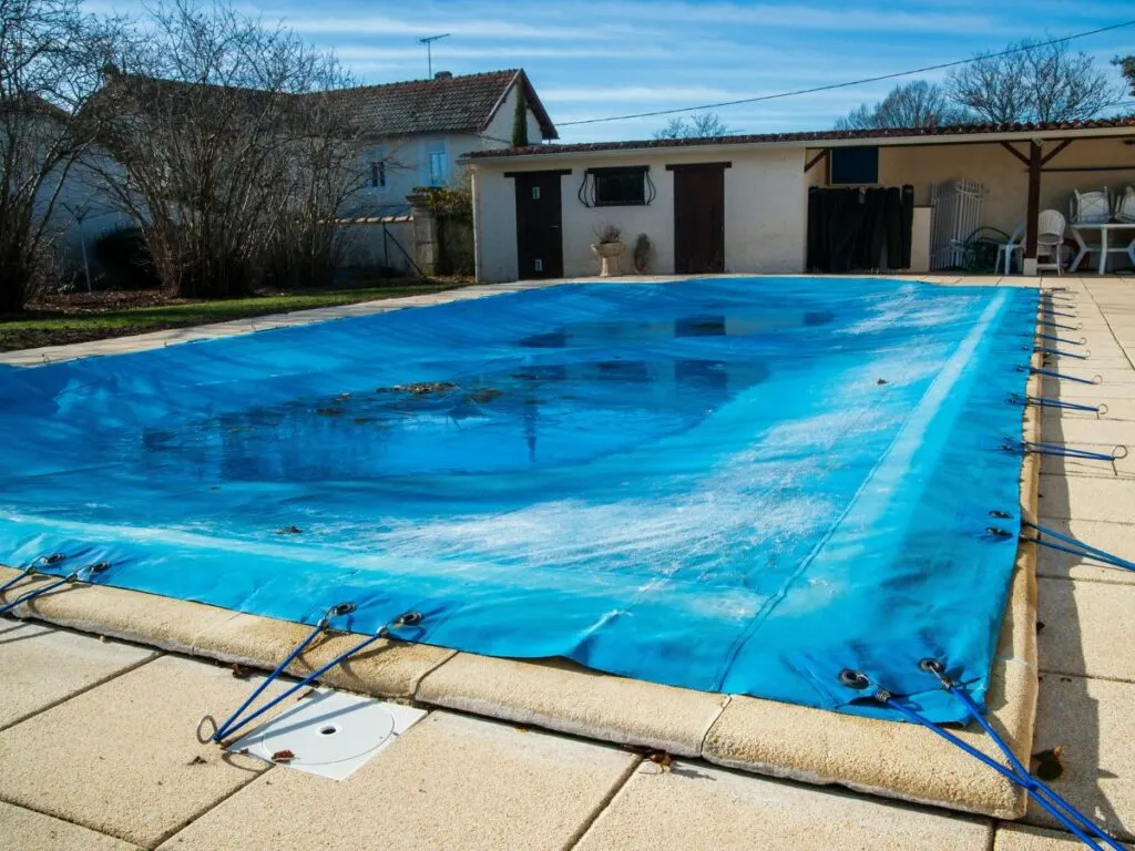 A blue tarp covering a swimming pool for winter.