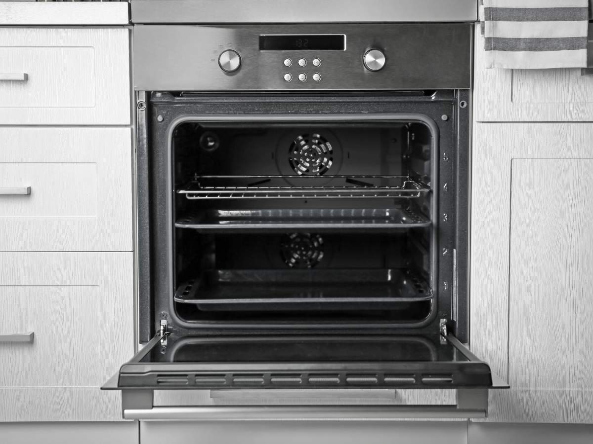A clean stainless steel oven with a door open.