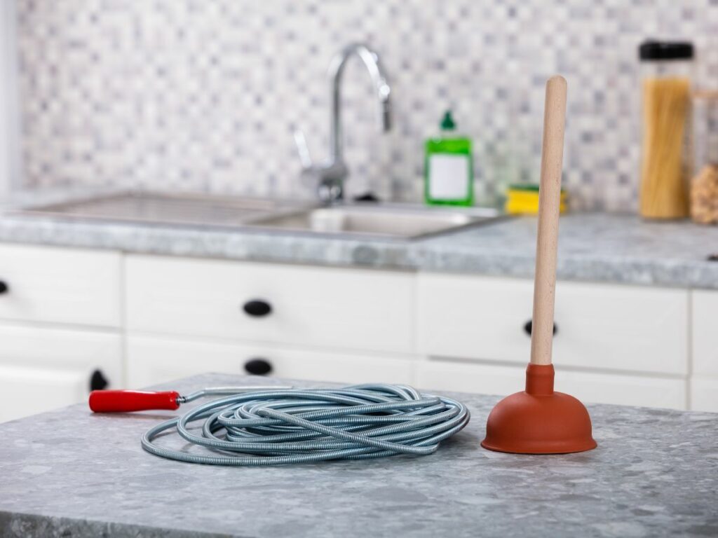 A plunger on a counter in a kitchen.