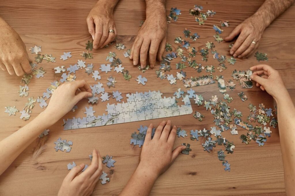 A group of people putting together a jigsaw puzzle.