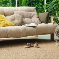 A sofa in a living room with a berber carpet.