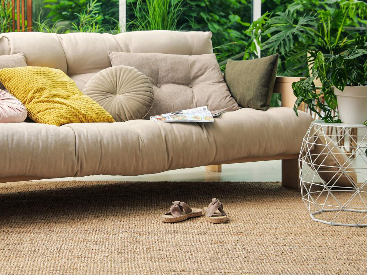 A sofa in a living room with a berber carpet.