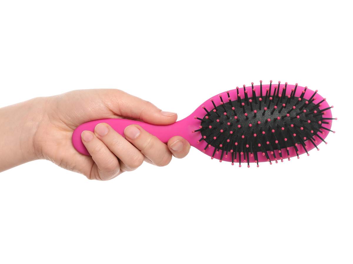 A hand holding a clean hairbrush.