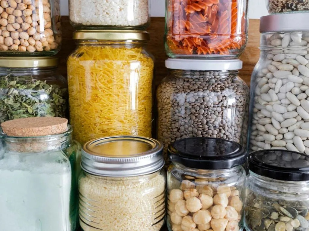 Many jars filled with different kinds of food for storage.