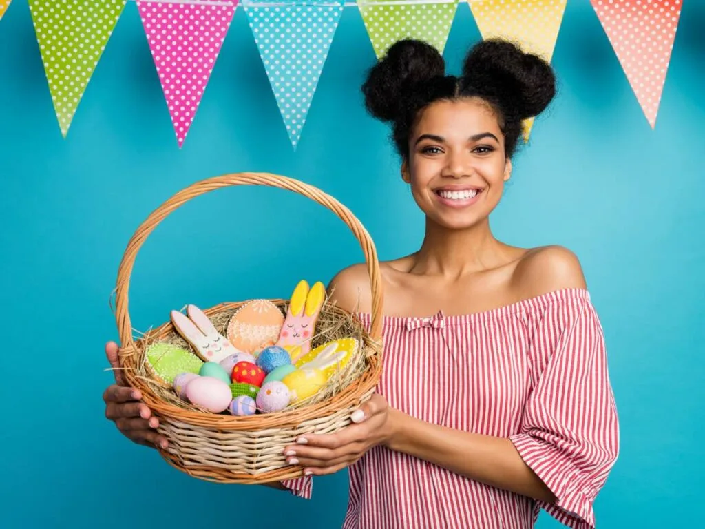 A young woman holding a basket of easter treats.