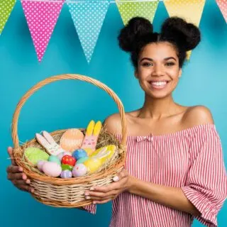 A young woman holding a basket of easter treats.