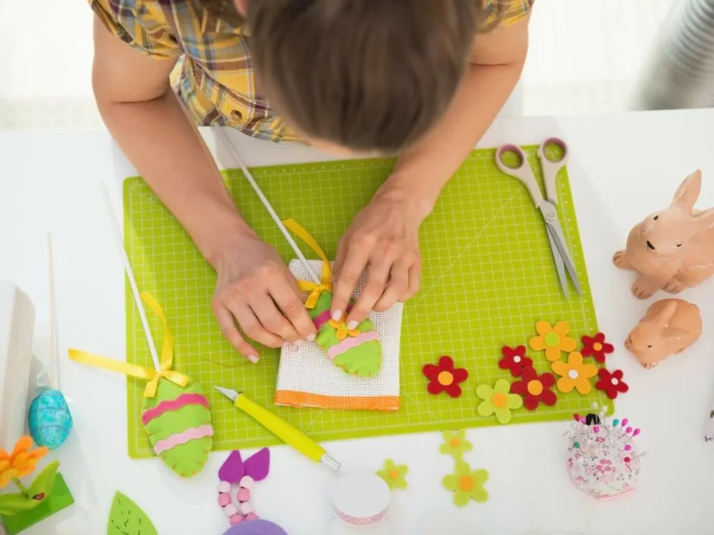 A woman is making easter crafts on a table.