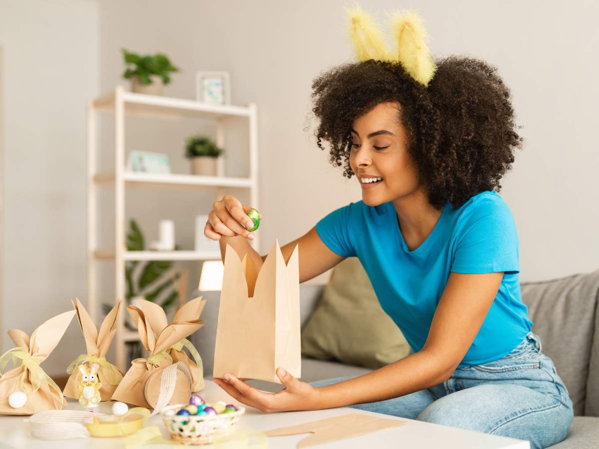 A woman with bunny ears sitting on a couch with easter decorations.