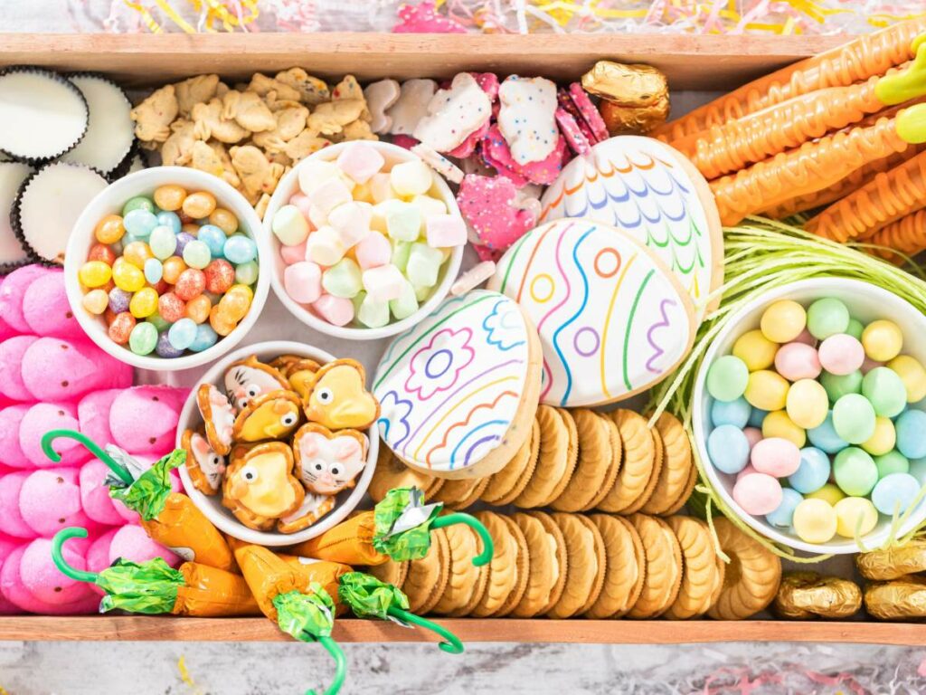 A wooden tray with a variety of easter treats.