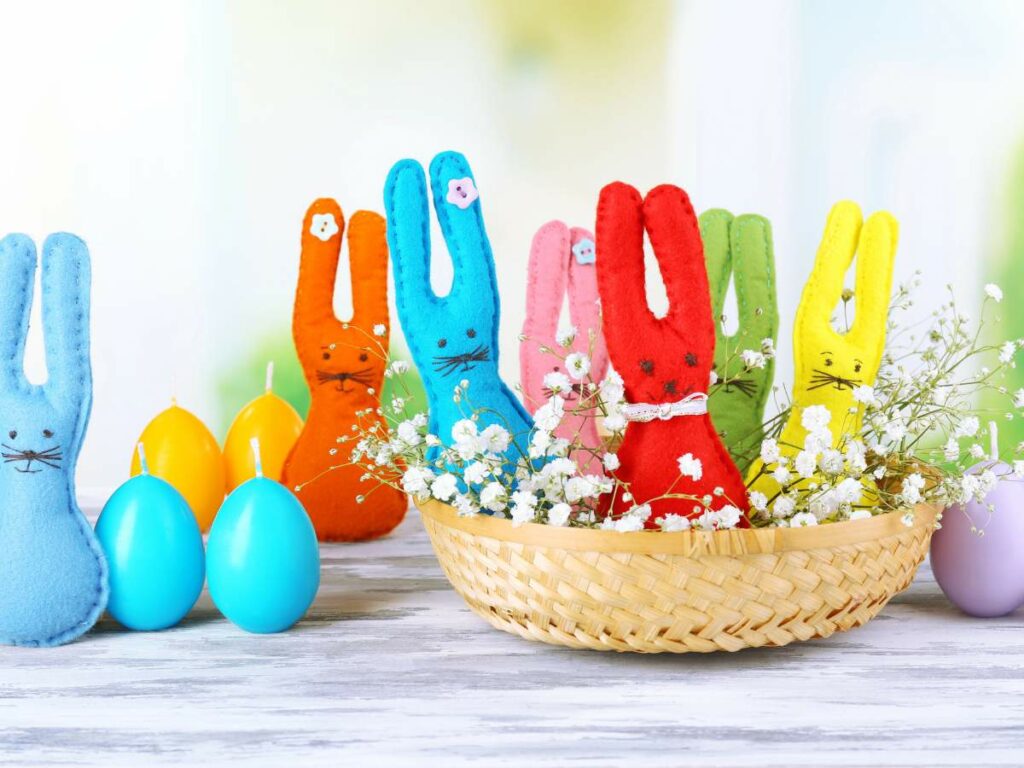 Colorful easter bunnies in a basket on a wooden table.