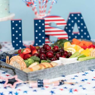 A vibrant display of fruit arranged in a tray at a patriotic-themed event with decorative 