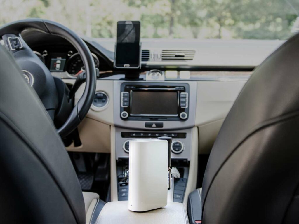 Interior view of a car from the backseat, showing the dashboard, steering wheel, and a gps device.