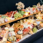 A two-tiered buffet table and a variety of serving utensils are present.