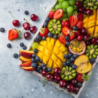 A wooden tray filled with an assortment of fresh fruits.