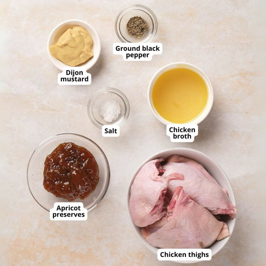 Ingredients for apricot chicken are arranged on a light surface.