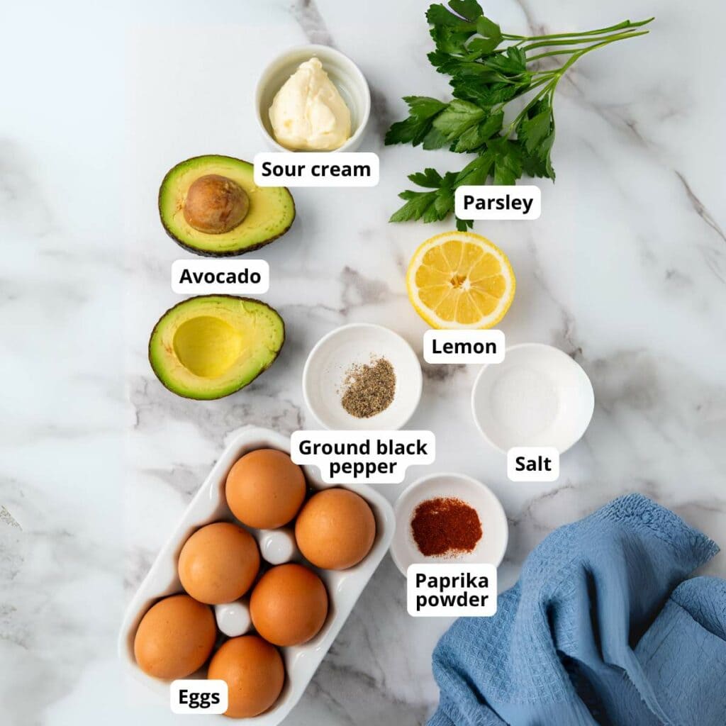 Ingredients for deviled eggs on a marble surface.