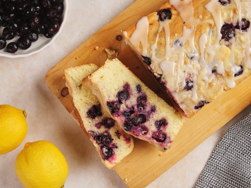 Lemon blueberry pound cake, sliced on a wooden board.