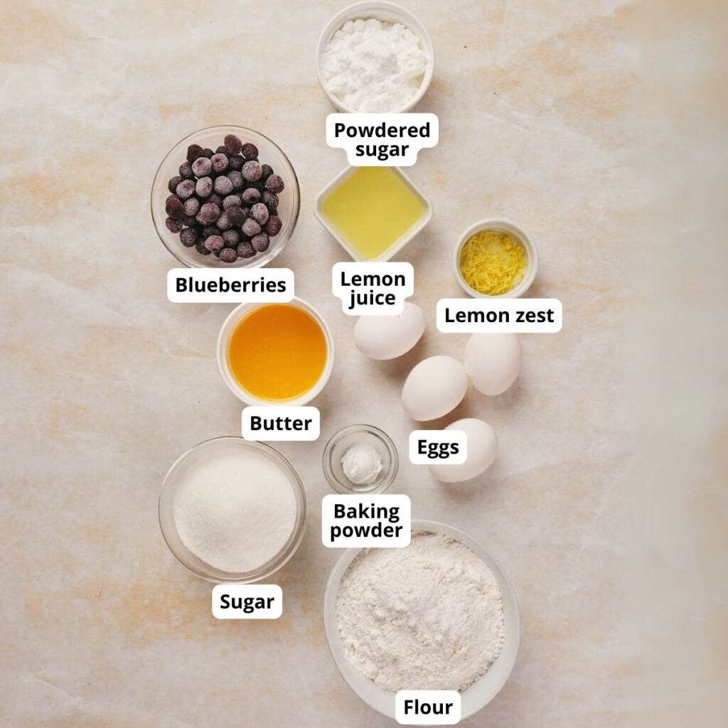 Ingredients for lemon blueberry pound cake recipe displayed on a light surface.