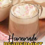 Two glass mugs of peppermint mocha topped with whipped cream and pink sprinkles on a wooden tray with a candy cane.