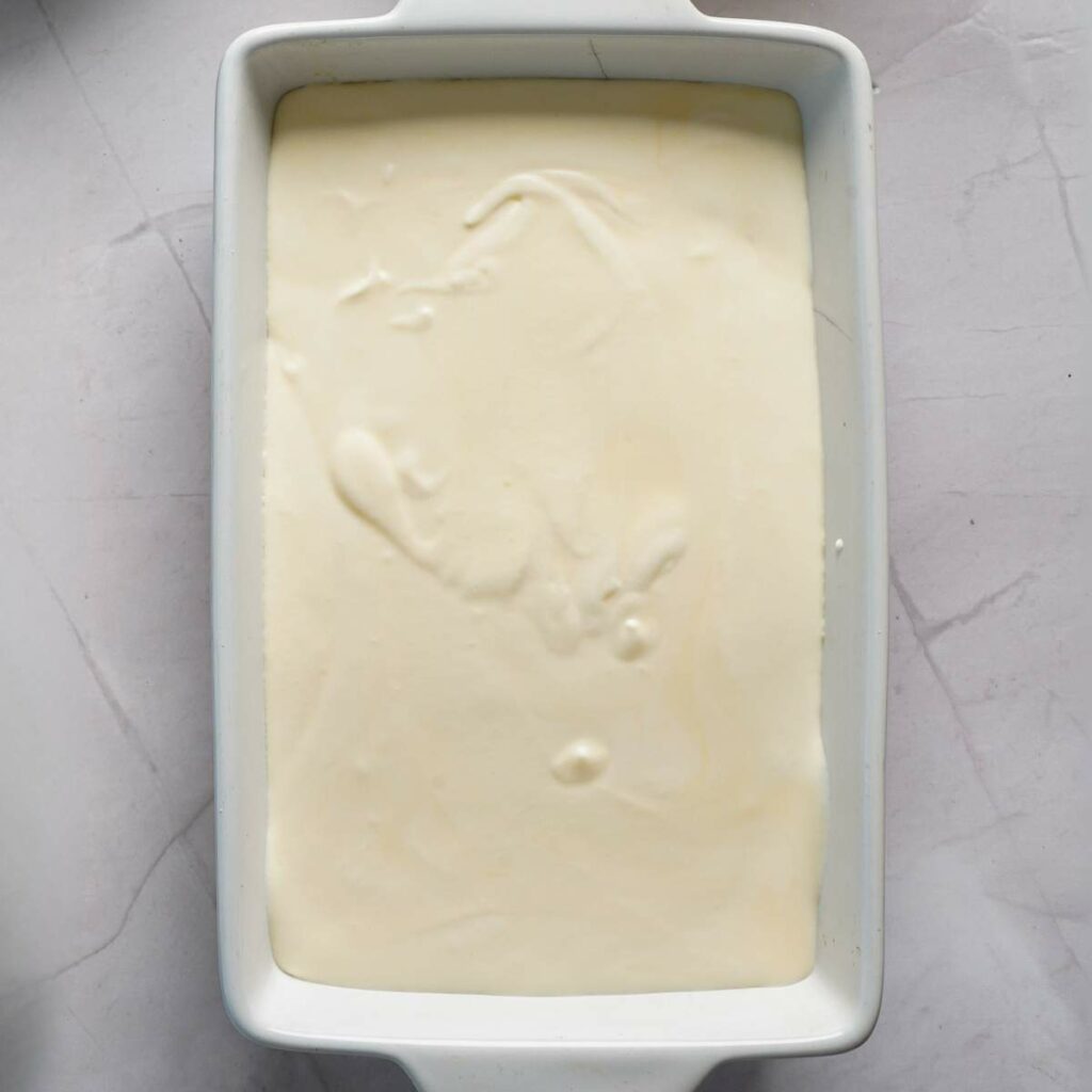 A rectangular white dish filled with a smooth, creamy, pale mixture spread evenly across the surface.