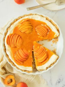 Apricot cheesecake with a creamy filling, topped with sliced apricots and apricot glaze.