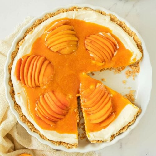 Apricot cheesecake with a creamy filling, topped with sliced apricots and apricot glaze.