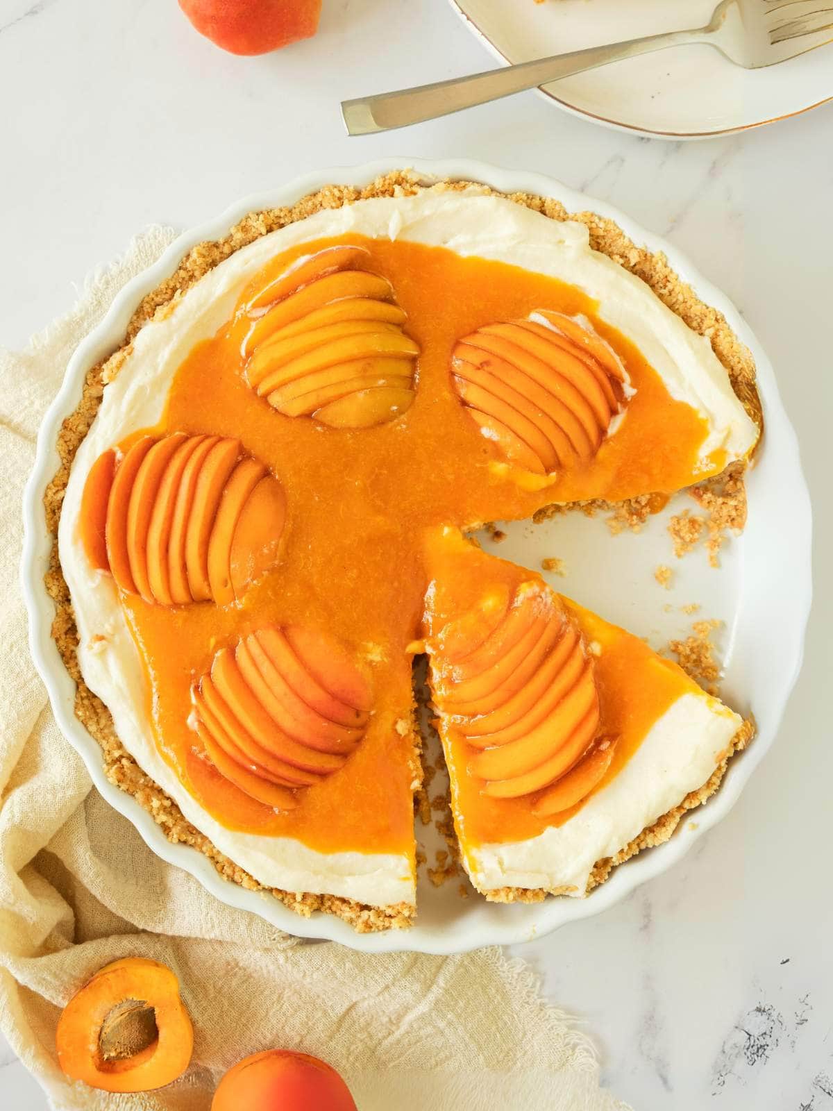Apricot cheesecake with a creamy filling, topped with sliced apricots and apricot glaze.