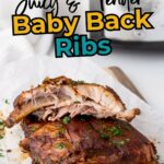 Two cooked baby back rib portions garnished with chopped herbs are placed on parchment paper.