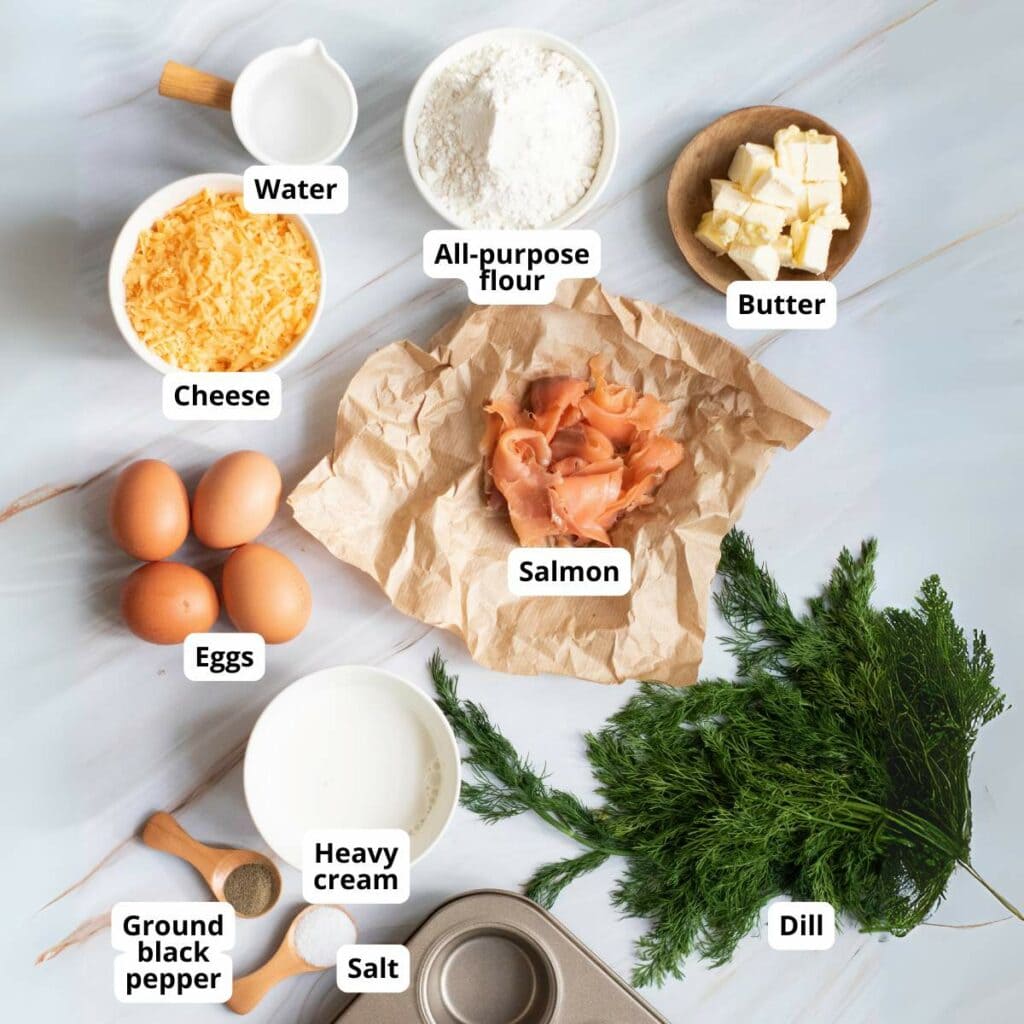 Ingredients for smoked salmon tartlets arranged on a marble surface.