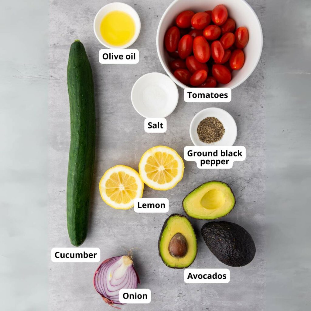 Ingredients for summer salad arranged on a light gray surface, each labeled with text.