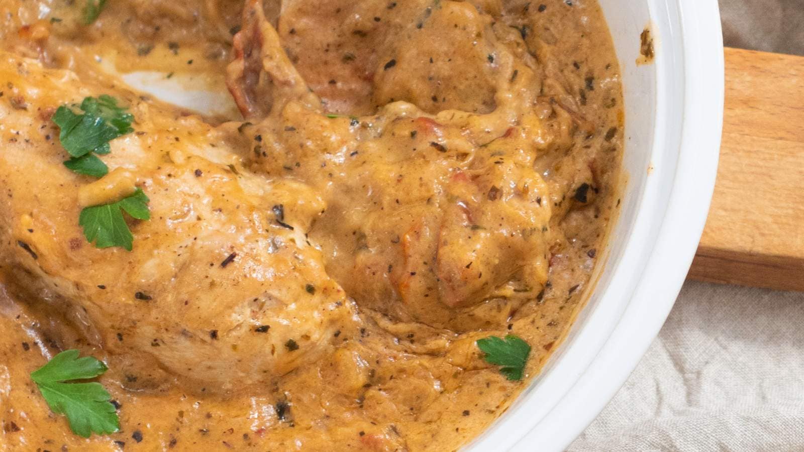 Close-up of marry me chicken garnished with parsley.