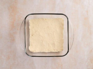 A glass baking dish filled with an even layer of pale yellow powder.