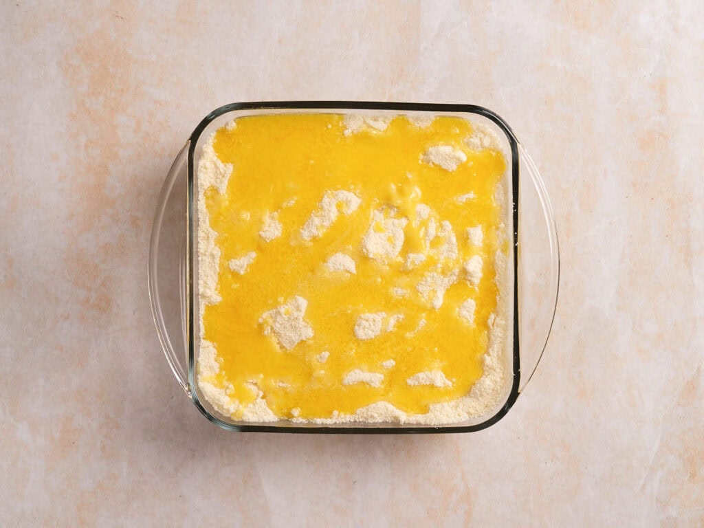 A glass baking dish filled with an even layer of yellow batter.