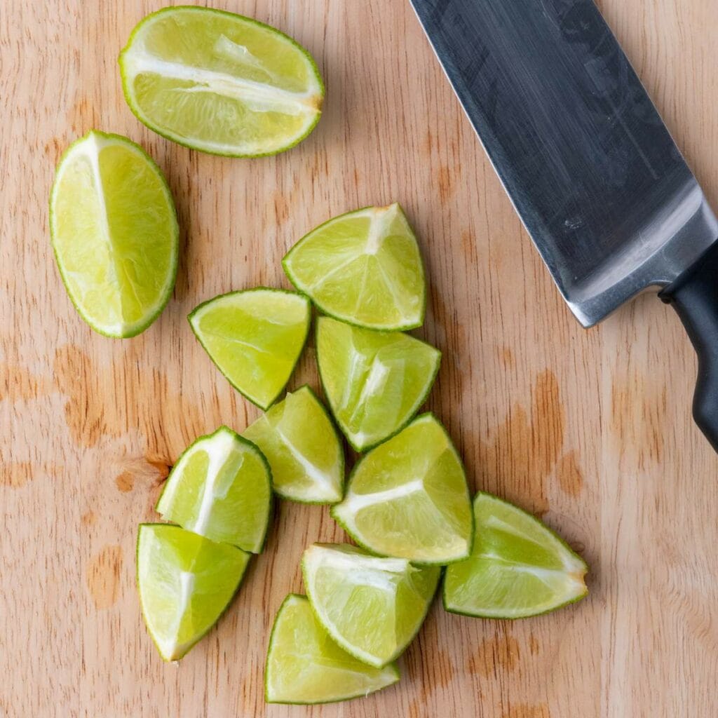 A black-handled knife and several lime wedges.