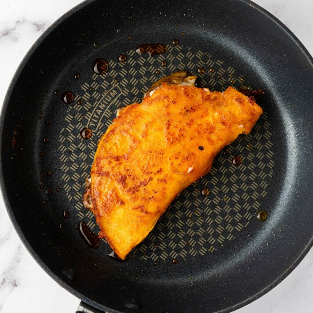 A golden-brown taco shell filled with meat.
