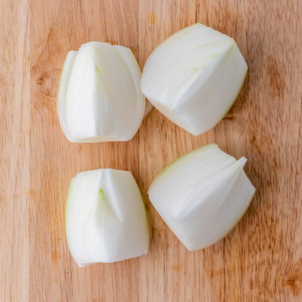 Four quartered pieces of a white onion.