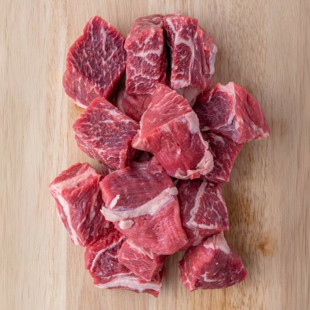 Several raw beef stew meat cubes.