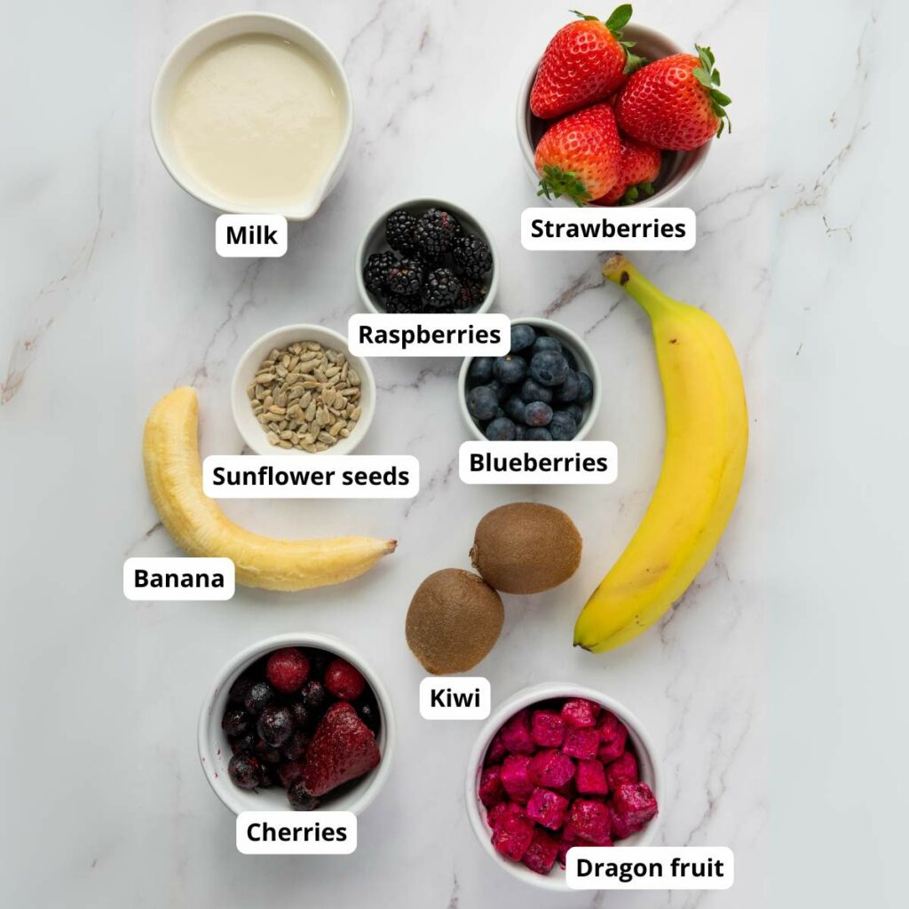 A variety of smoothie ingredients on a white surface.
