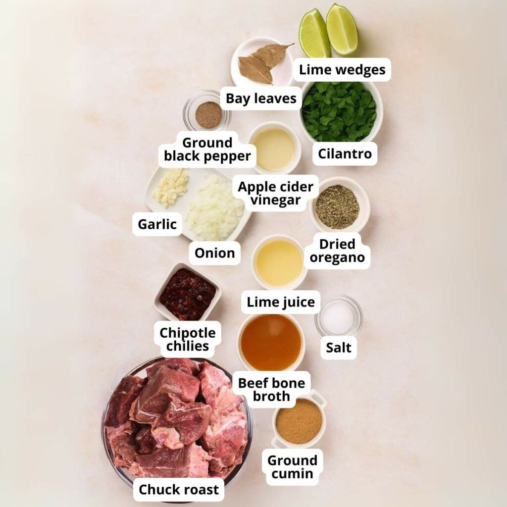Various labeled ingredients for a barbacoa on a light surface.