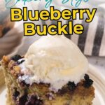 A slice of blueberry buckle cake topped with a scoop of vanilla ice cream on a white plate with a fork.