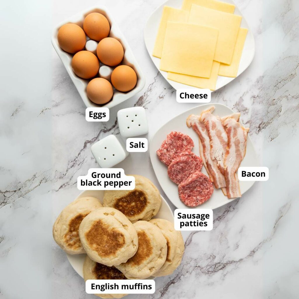 Top-view of labeled ingredients for make ahead breakfast sandwich arranged on a marble surface.