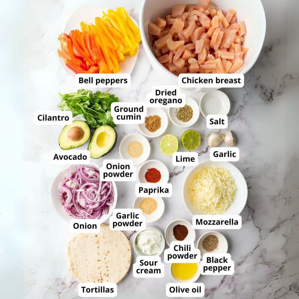 A flat lay labeled ingredients of sheet pan chicken fajitas arranged on a marble surface.