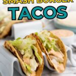 Two smash burger tacos with lettuce and sauce are placed in taco holders, with more tacos and a dipping sauce visible in the background. Text overlays promote the recipe.