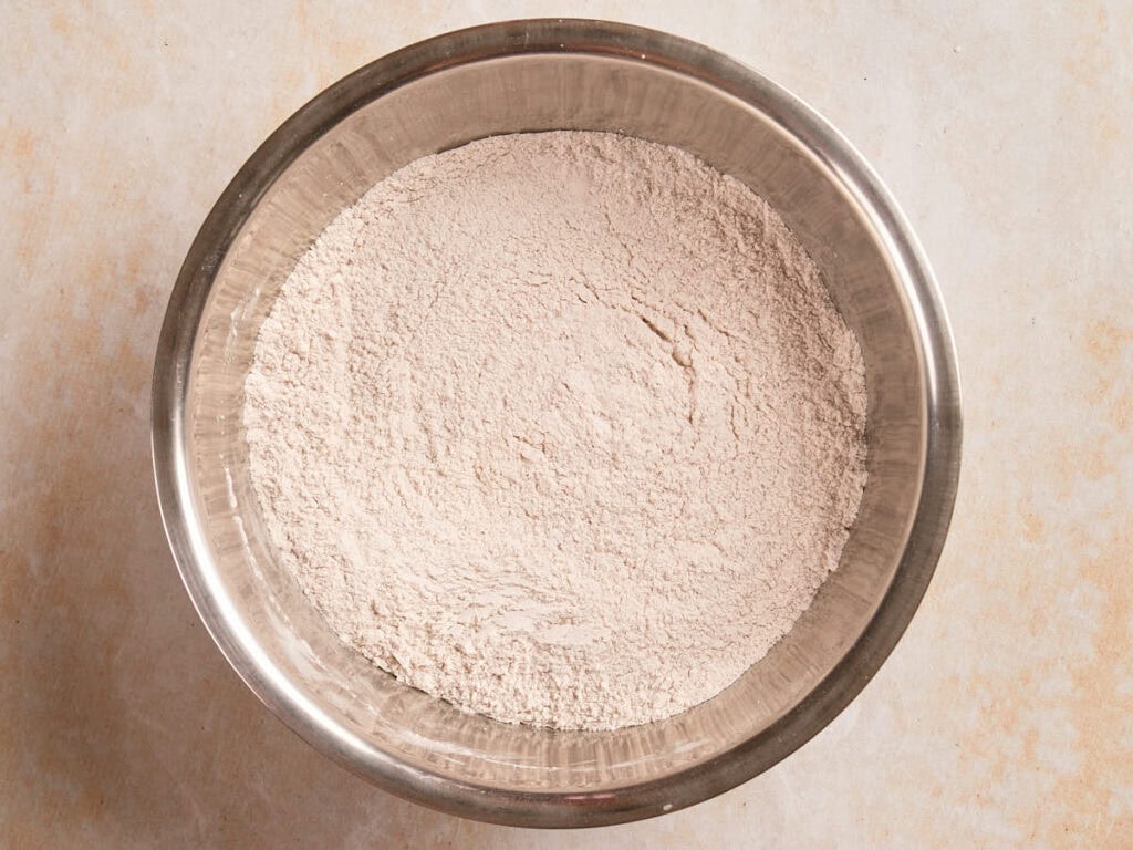 A metal bowl filled with a mound of flour.